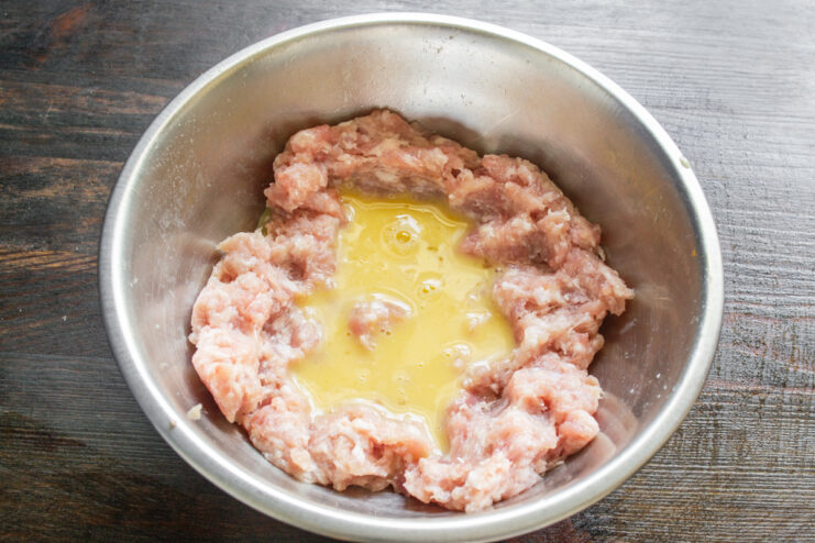 Добавление взбитого яйца в мясной фарш