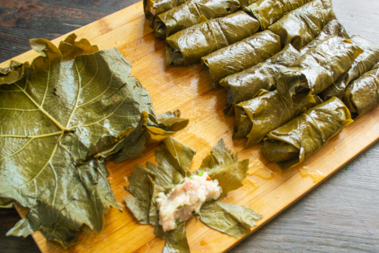 Процесс заворачивания куриного фарша с рисом в виноградные листья