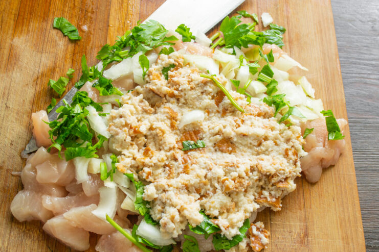 Размоченный хлебный мякиш, добавленный к куриному филе с луком и зеленью