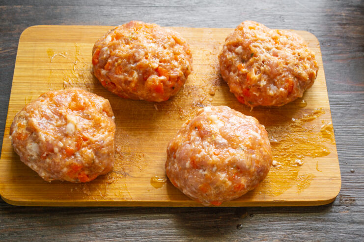 Сформированные круглые мясные котлеты на доске