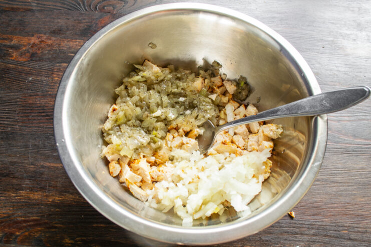 Добавление обжаренного и сырого лука к нарезанной курице