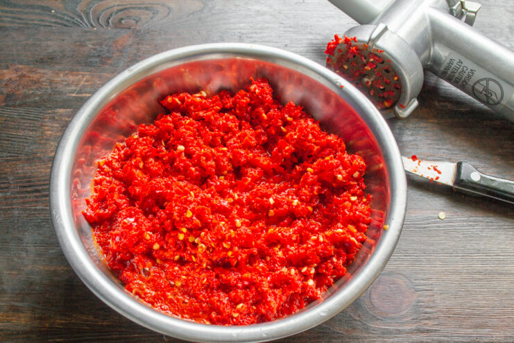 Измельченная масса из перца и чеснока в миске после мясорубки