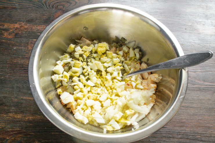 Измельченные вареные яйца в миске с курицей и луком