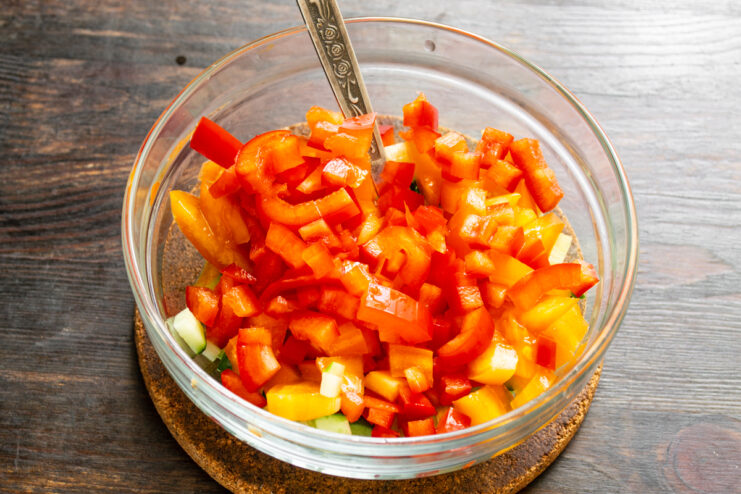 Красный сладкий перец кубиками в миске с овощами