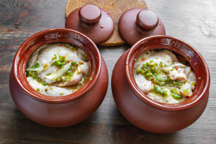 Заполнение горшочков курицей Куриные бедра в глиняных горшочках поверх слоя овощей