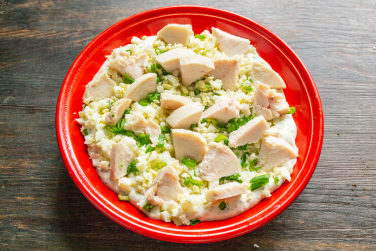 Кусочки куриной грудки, выложенные поверх яичного салата