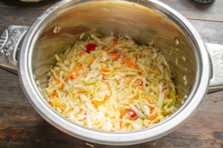 Перемешанная капуста с помидорами в кастрюле