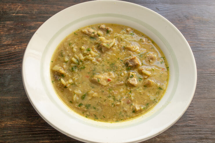 Порция супа харчо с рисом Порция горячего супа харчо с рисом и мясом в глубокой тарелке