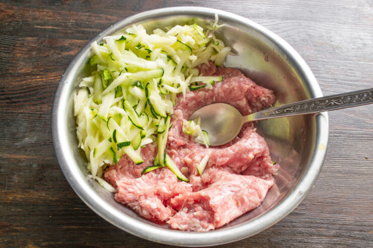 Тертая мякоть кабачка и мясной фарш в миске